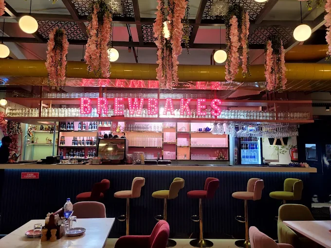 The Brewbakes interior with its glowing magenta neon sign